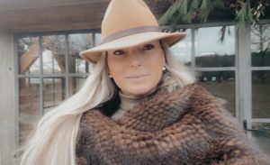 Elegant woman wearing a stylish hat and a luxurious fur scarf, exuding sophistication and charm.