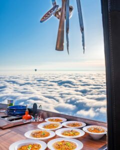 A breathtaking sky dining adventure in a hot air balloon, with a delicious meal served amidst the clouds.