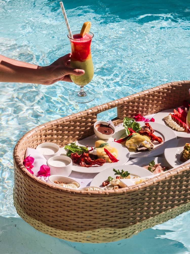 Beautifully filled breakfast basket floating on a private pool at Zanzibar White Sand Luxury Villas & Spa, offering a luxurious and relaxing start to the day.