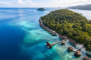 Aerial view of Papua Paradise Eco Resort with overwater bungalows in Raja Ampat, Indonesia.