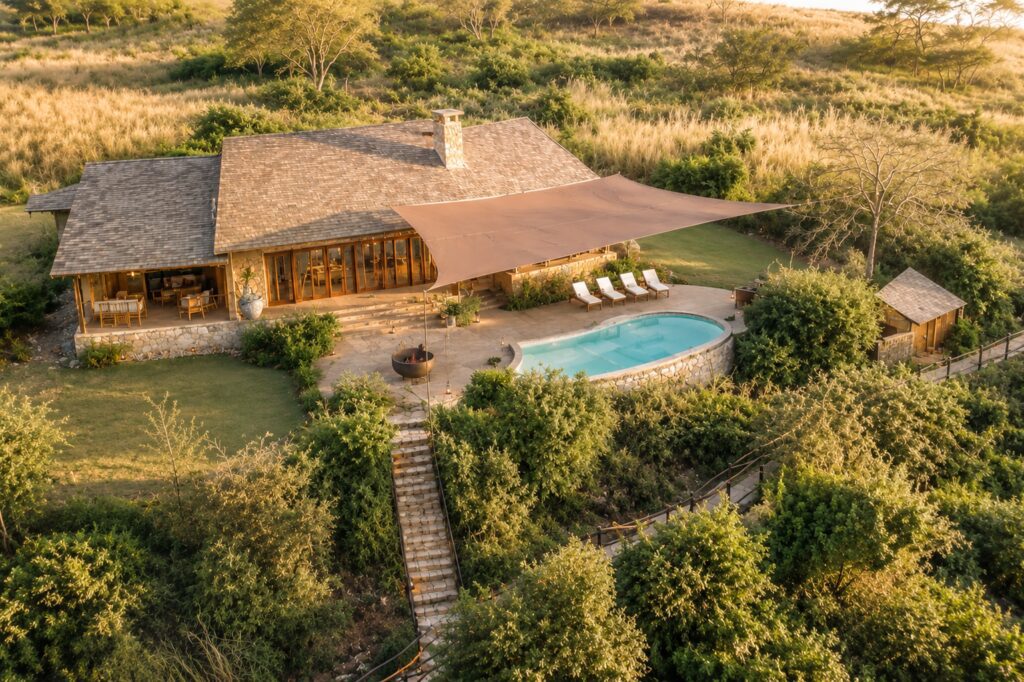 Aerial view of The Emakoko luxury safari lodge overlooking Nairobi National Park at golden hour, Kenya.